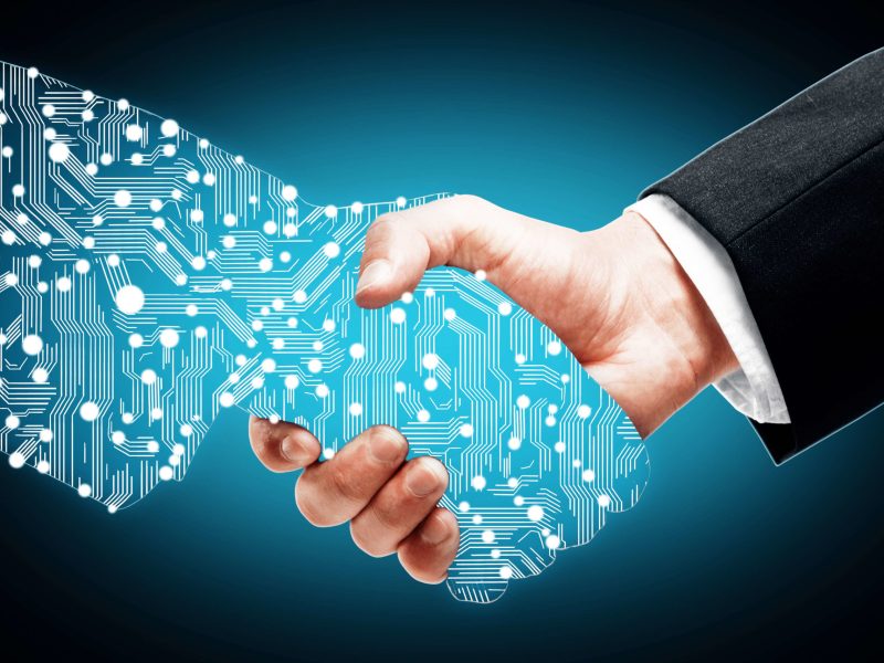 Businessman shaking digital partners hand on blue background